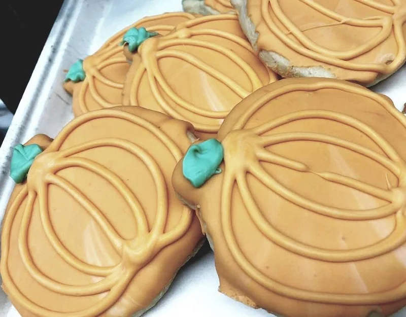 Pumpkin-shaped cookies decorated with golden icing