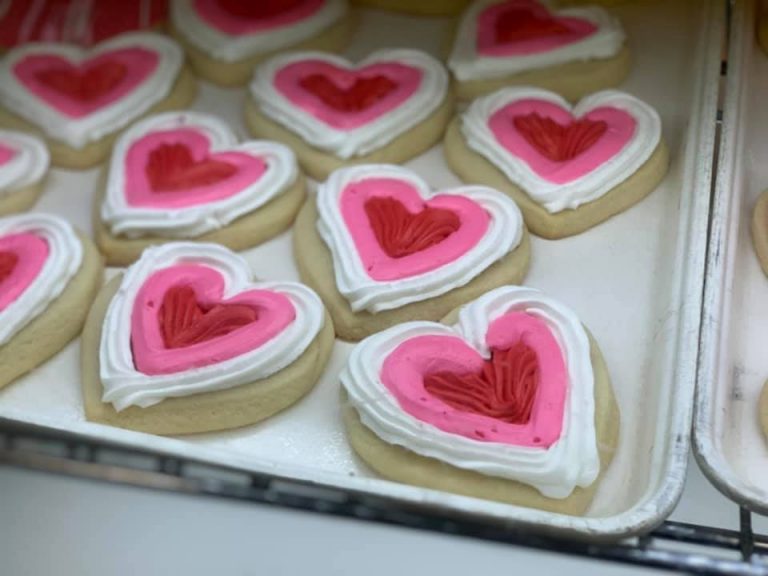 Heart-shaped cookies with white borders and pink and red icing