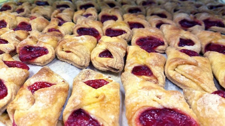 Rows of golden kolaczki with fruit filling